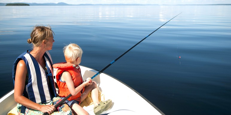 Mor og søn på fisketur i robåd på en sø