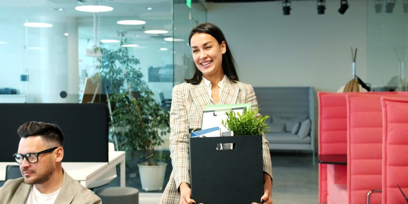 Woman leaving office with a box of personal items