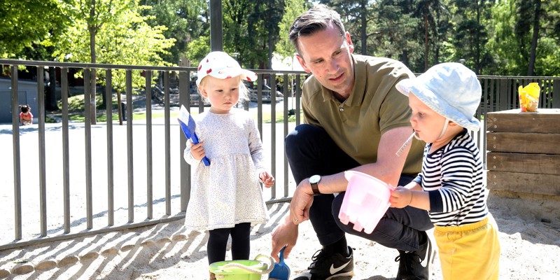 Dad playing with his children in a sandbox