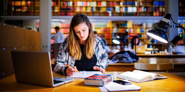 Studerende læser på bibliotek