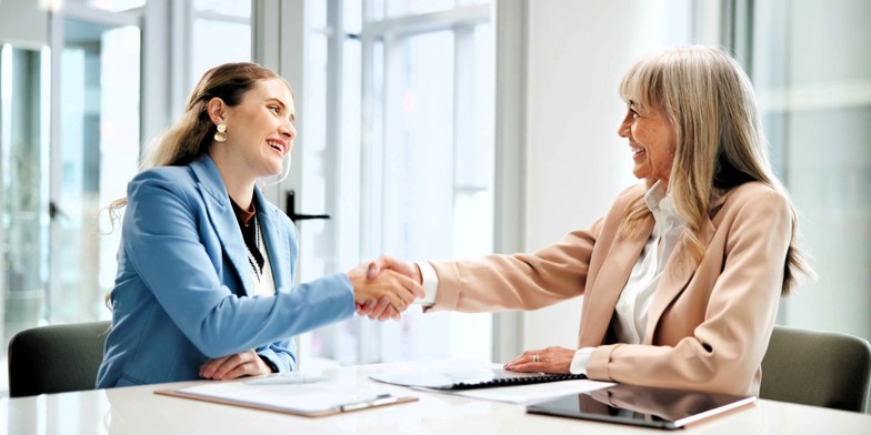 Employer and employee shaking hands after signing an employment contract.