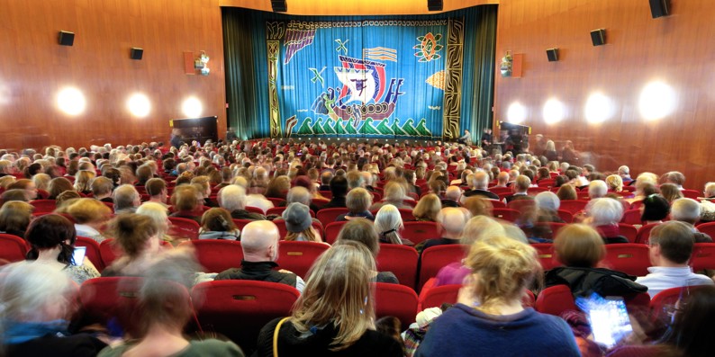 Fyldt teatersal før forestilling med blik mod scenen