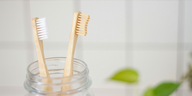 Two toothbrushes in a glass