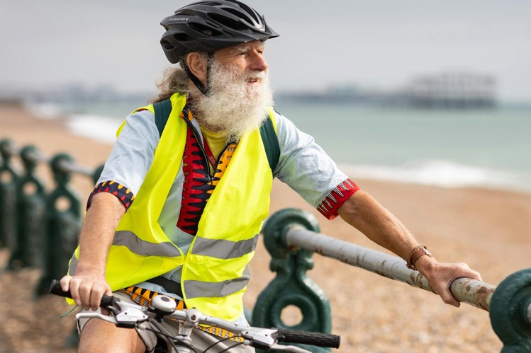 Ældre mand på cykel ved strand